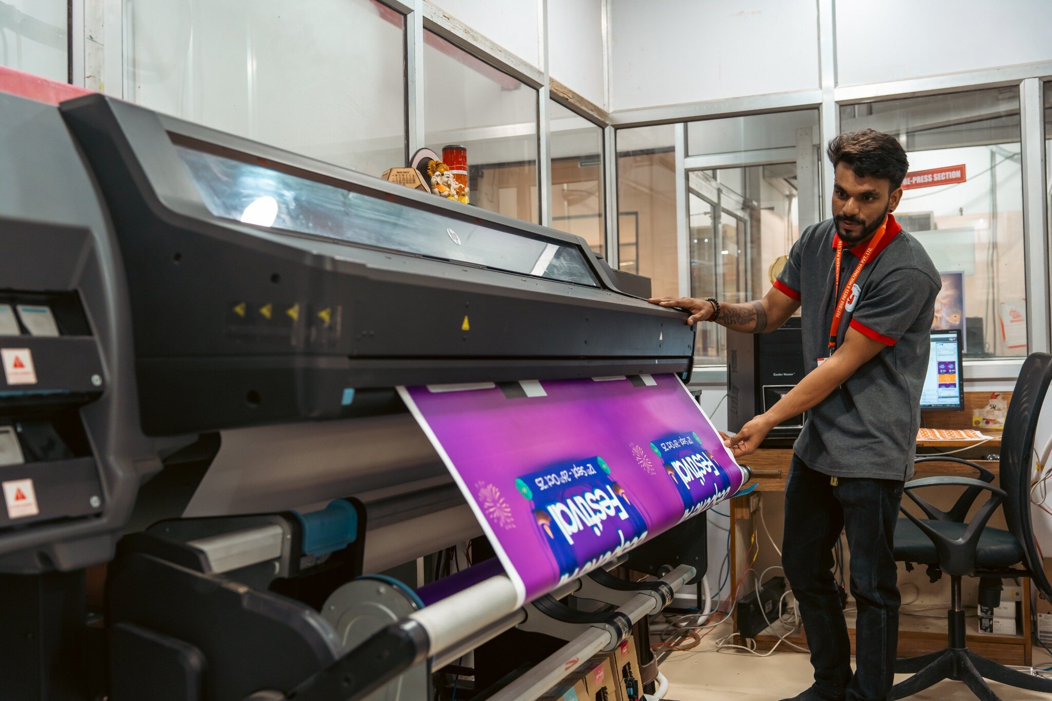 A PPML team member operating a large-format digital printer.